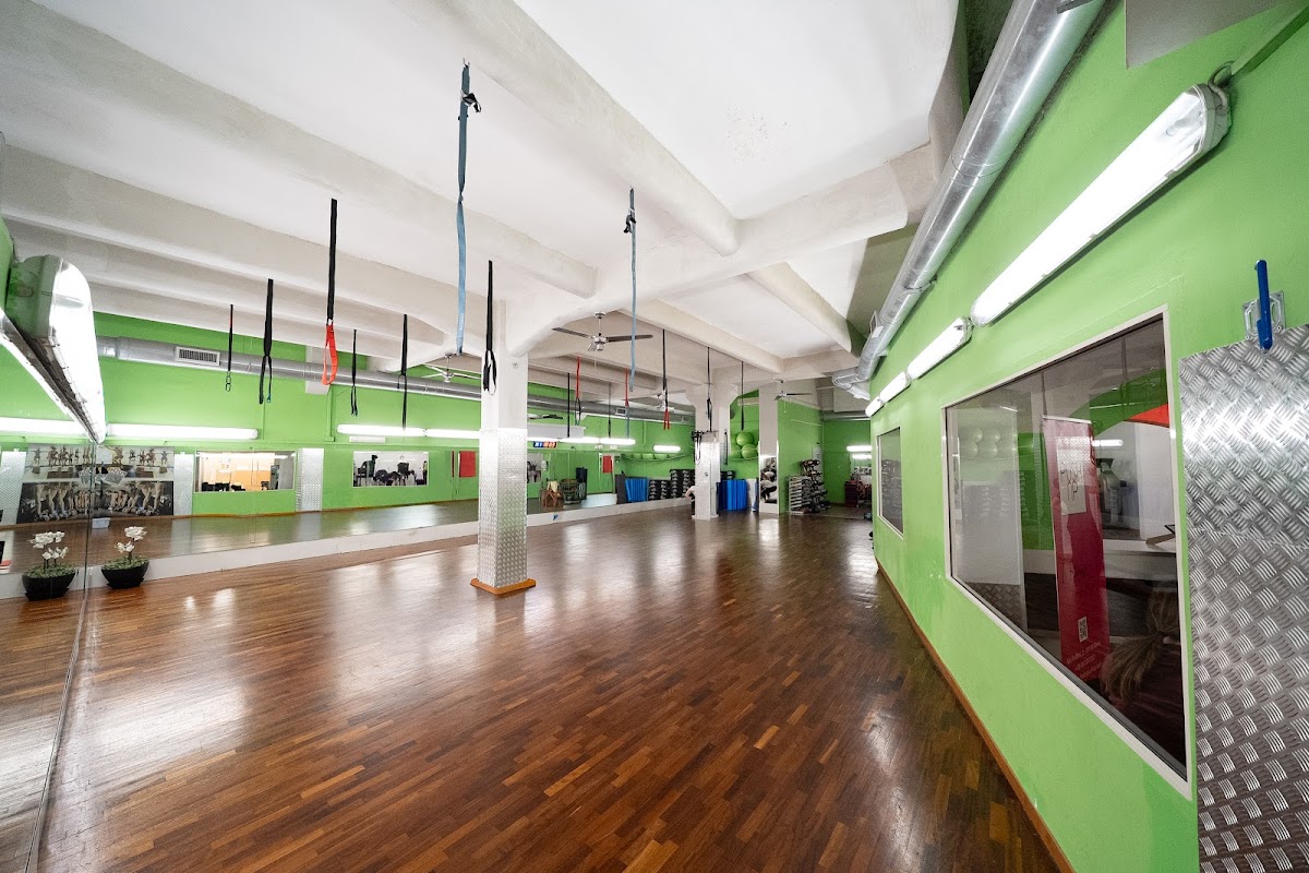 Sala functional con attrezzi sospesi e parete verde
