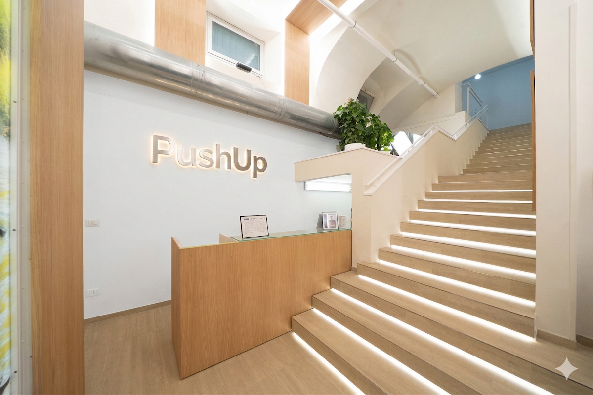 Reception di Push Up con la scritta a parete e scalinata illuminata